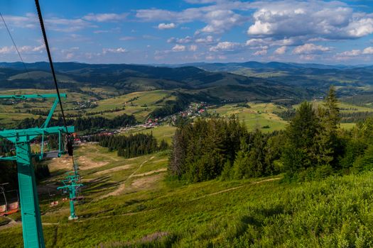 The picturesque nature of the mountainous terrain with peaks, hollows, slopes, roads and houses.
