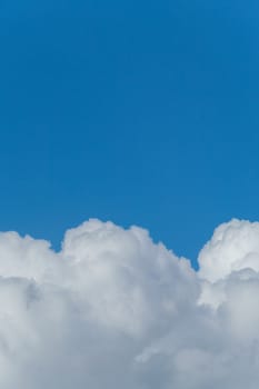 Lush massive white clouds against the background of the endless blue sky
