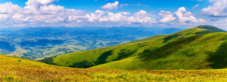 bright peaks of the Carpathians are covered with green grass, over which white fluffy clouds swim