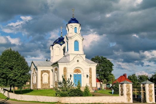 Cloudy, cloudy sky over the church with a blue roof. Looks good