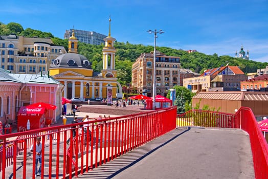 The alley fenced with red handrails descends into a beautiful city with colorful houses