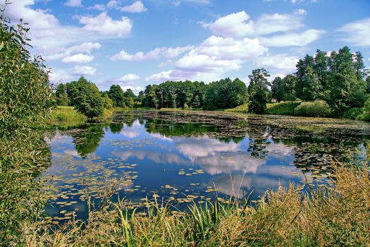 The blue sky is reflected in the forest crystal clear lake. Grace for the soul