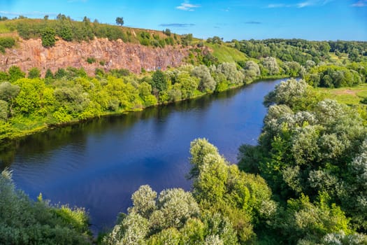 River bay with clear blue water on a background of rocky mountain and green plantations