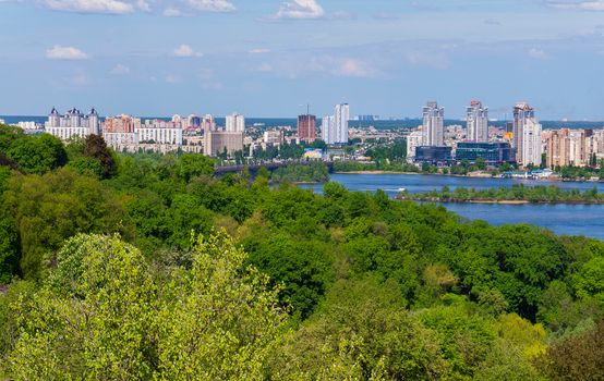 high high-rise buildings of the city among the lush green parks near the Dnieper River. Kiev. Ukraine