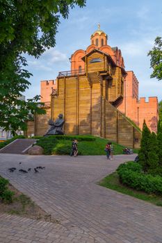 a monument of architecture and artwork Golden Gate in Kiev among green trees against the backdrop of the sunset cloudless sky. a place for recreation and tourism
