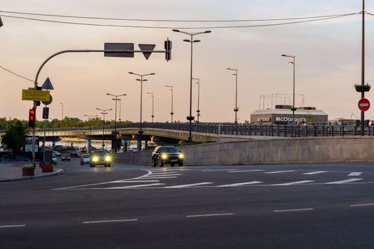 Cars traveling along the highway against the backdrop of the bridge and the embankment