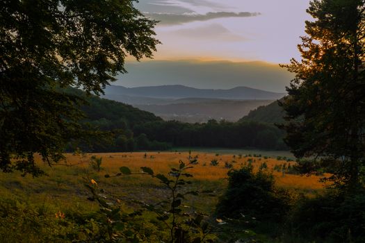 lawn with mountains in the background during sunset