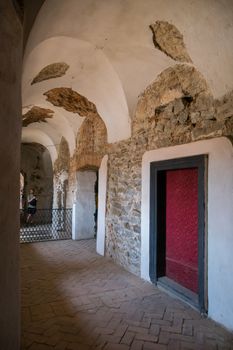 the door in the castle corridor with thick walls and archway ceilings. Place of visit of tourists