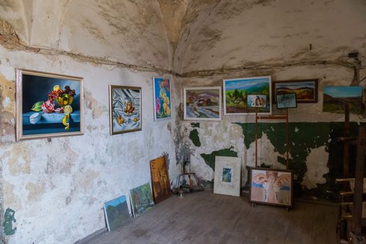 Beautiful paintings on different subjects hanging on the wall in the museum room