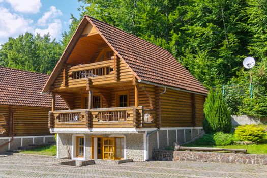 Cozy wooden three-storey villa with wide panoramic balconies and a tiled roof