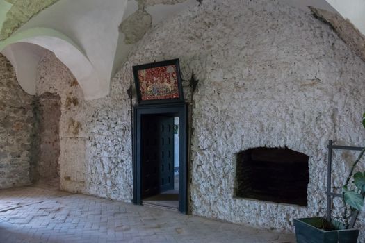 An old beautiful picture over the door of a room with stone walls