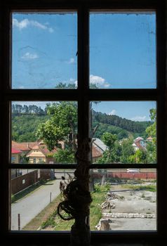 dried flowers on window sills with windows overlooking the country houses near the hill