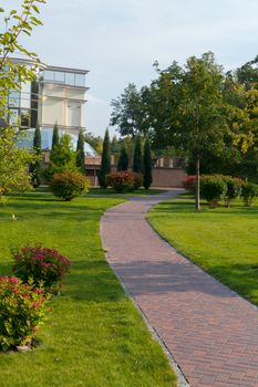 tiled track that leads to the house with a glass dome in a beautiful park