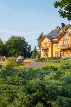 A beautiful mansion with chopped up trees with alleys made of bruschatka, ancient lanterns and flower beds