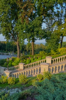 beautiful railing-columns near concrete stairs in a park with green plantations leading to the area for recreation