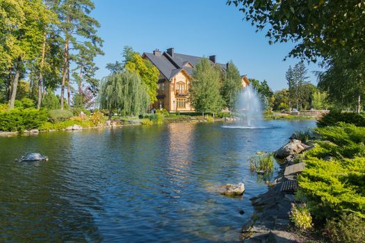 a magnificent artificial pond and a fountain hammering out of it near the country house