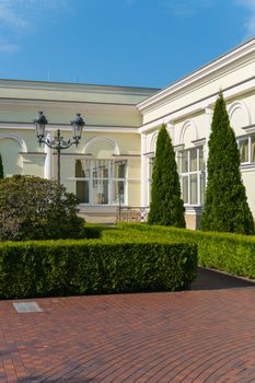 Parked with red tiles, a walking promenade with smoothly cut ornamental bushes