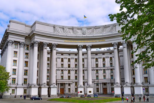 Facade of the Ministry of Foreign Affairs of Ukraine against the blue sky. Patriotically, the flag flies from the wind on the roof