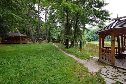 gazebos along the path under tall trees on the lake shore
