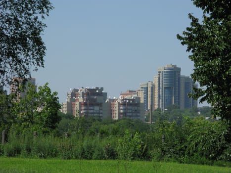 Urban high-rise buildings against a background of green trees and shrubs