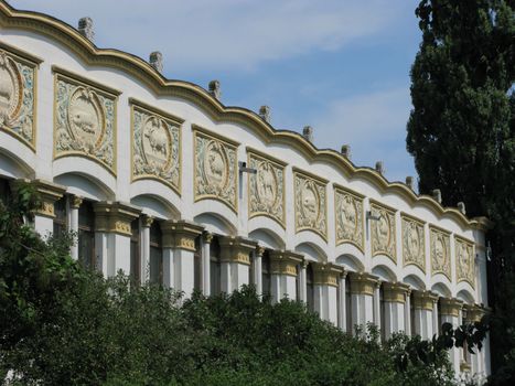 White-gold building with columns and carved ornament with the image of different animals