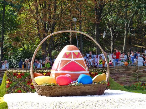 a large Easter basket with colorful eggs-krashenkami against the background of the fence