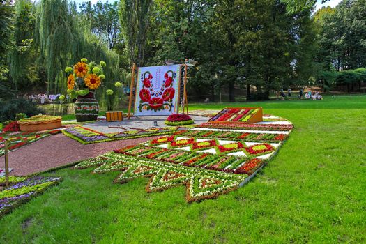 The flower bed is decorated in Ukrainian style with a vase, loaf and embroidered towel
