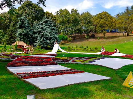 Installation in the Ukrainian style with the girls who embroider a towel passing into the flower bed