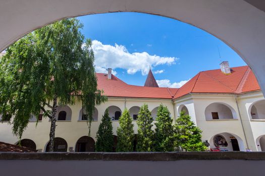 View from the window to the nearest building of an old castle with a red roof