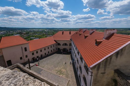 Fascinating view from above into the courtyard of the castle against the background of the city of a blue cloudy sky in the background