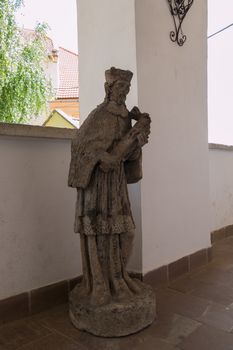 High stone statue in the spacious corridor of a medieval old castle