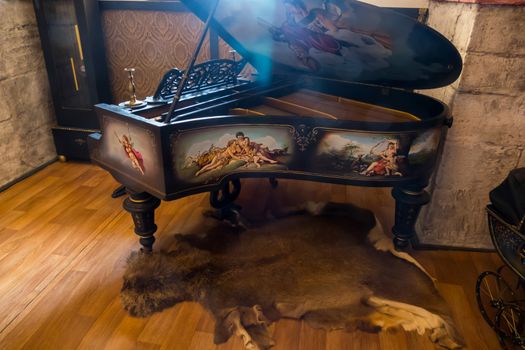 An ancient piano standing on the skin of an animal with pictures painted on its sides