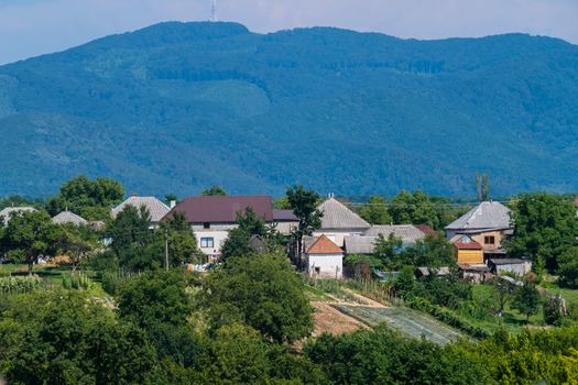 A small rural village is located in a cozy distance from the green rolling mountains