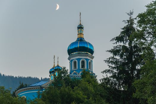 a majestic moon in a cloudless sky above the dome of the church