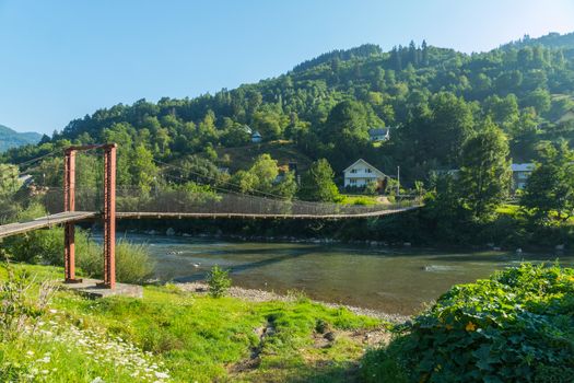 cloudless sky above the cable bridge over the mountain river