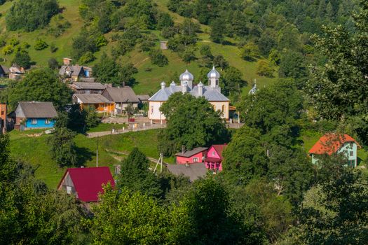 A small settlement consisting of one-story houses with colored roofs and a church in the middle of this settlement