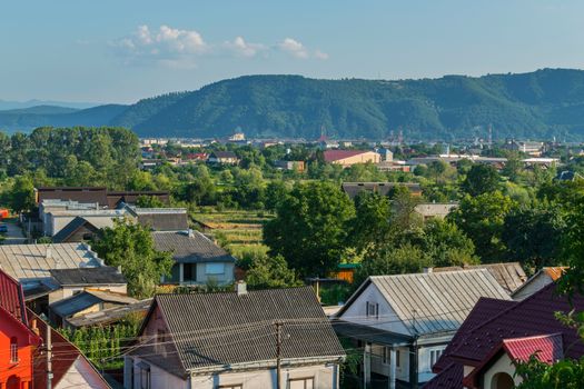 Imbuedly floating clouds above the green tops of the mountains and sleepy city