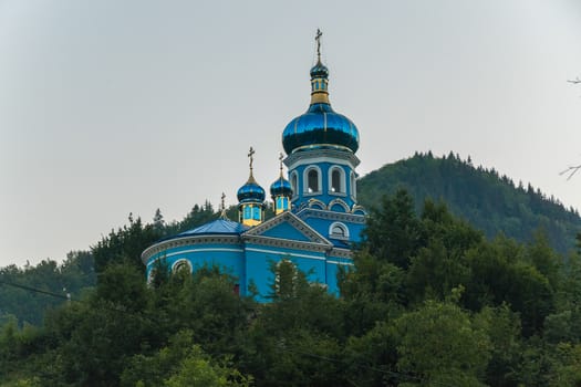 emerald turquoise tops of churches drowning in lush foliage of trees