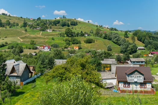 neat rural houses scattered in a valley on a green grass