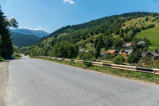 a wide track with a bump along the village on a mountain slope