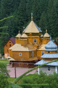 high spiers over the golden roofs of the church against the background of green spruce trees