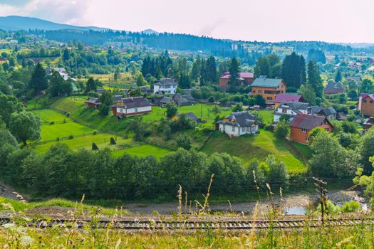 beautiful and well-kept houses on green grass carpets in a mountain valley