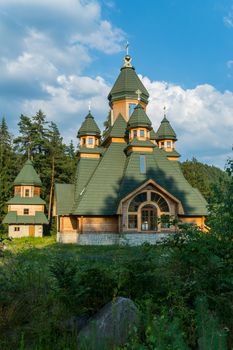a beautiful building of a low church with crosses under a blue sky with white clouds