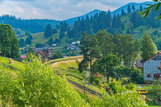 The railway makes a turn on the background of the village and the picturesque nature around it.