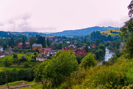 railway with a view of the river and the bridge in the background of a mountain village