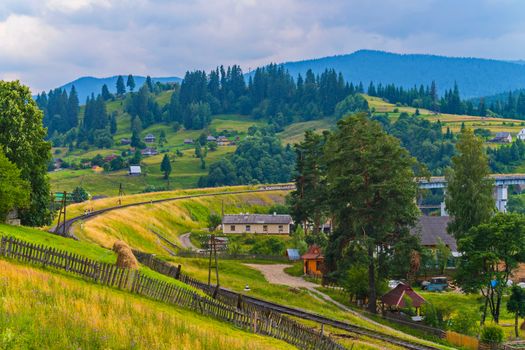 A village with beautiful houses and beautiful nature, through which a railway is laid