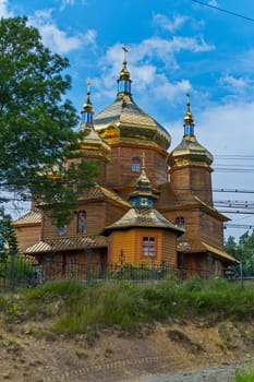 superb wooden church shining with gold domes on a background of blue sky