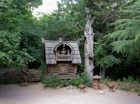 a decorative wooden house with a terrace and bear statues in the park