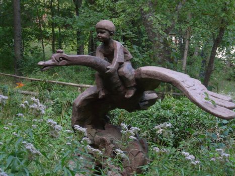sculpture of a boy riding on the swan of the heroes of the folk tale and ivasik telesik standing in the park