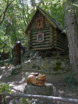 Sculptures of an orange cat and Baba Yaga on the background of a hut on chicken legs